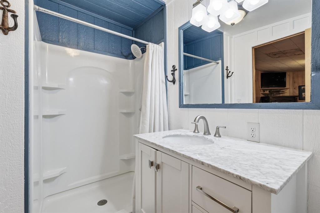 4513 Chapel Road Graham, TX 76450 - Photo 17 of 38 a bathroom with a sink vanity and a mirror