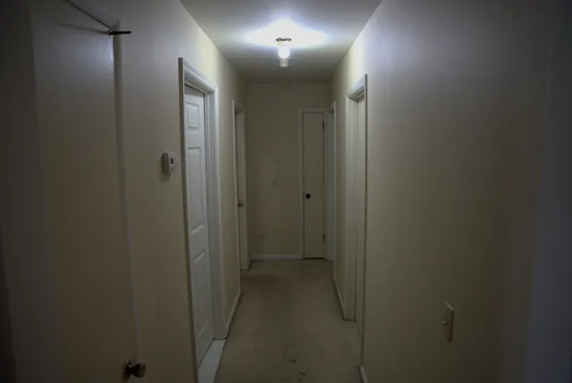 a view of a hallway with wooden floor and a chair
