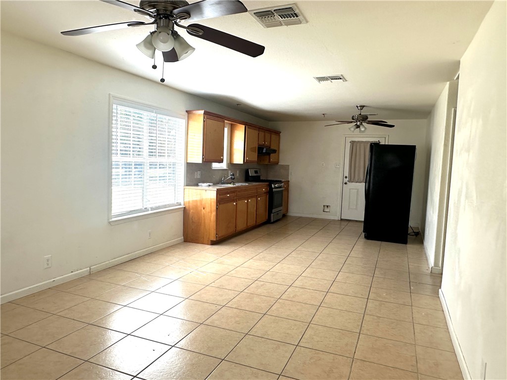716 Sodville Road Sinton, TX 78387 - Photo 2 of 11 a kitchen with granite countertop a refrigerator and a stove top oven