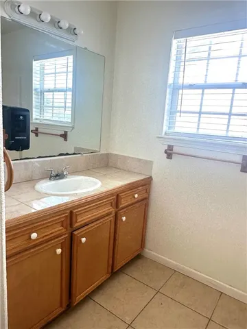 a bathroom with a granite countertop sink a mirror and a bathtub
