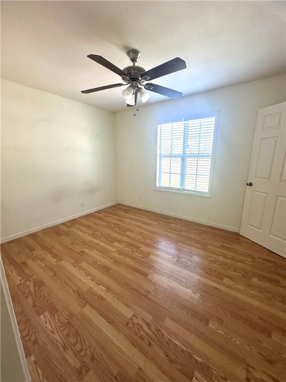 716 Sodville Road Sinton, TX 78387 - Photo 7 of 11 an empty room with wooden floor fan and windows