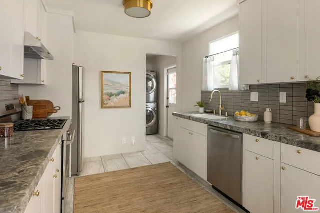 a kitchen with granite countertop a sink stove and cabinets