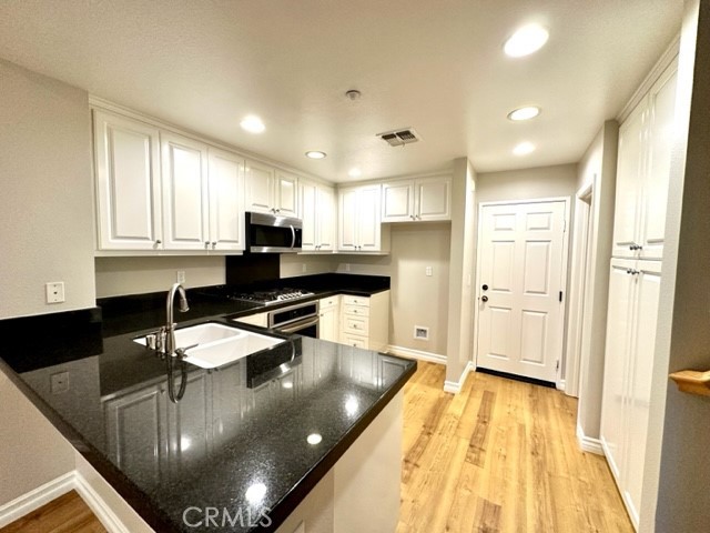 10 Paseo Rosa San Clemente, CA 92673 - Photo 5 of 46 a kitchen with stainless steel appliances granite countertop a sink refrigerator and cabinets