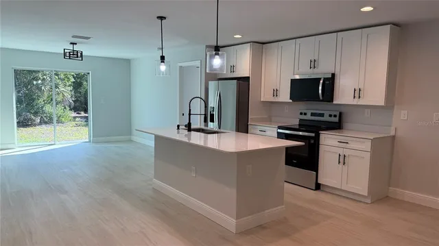 a kitchen with stainless steel appliances granite countertop a sink a stove and a refrigerator