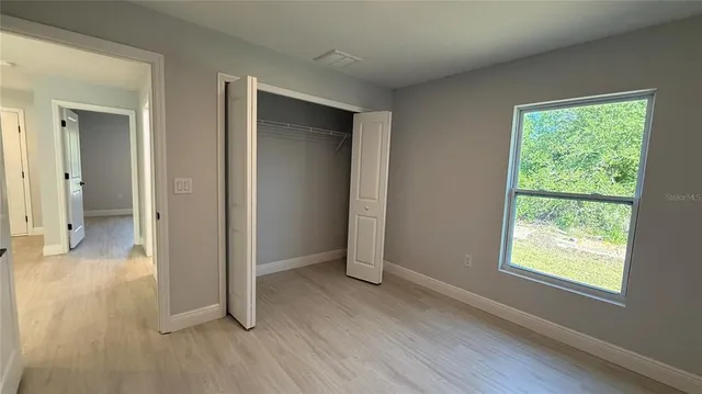an empty room with wooden floor and a window