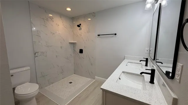 a bathroom with a sink a toilet and a mirror