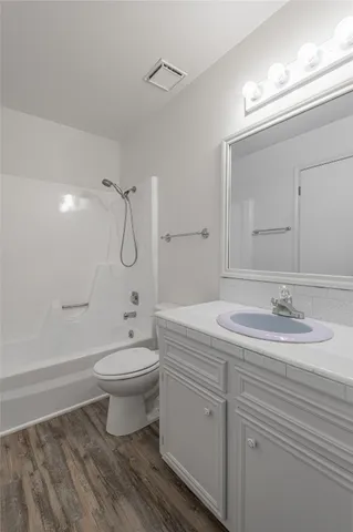 a bathroom with a double vanity sink toilet mirror and shower