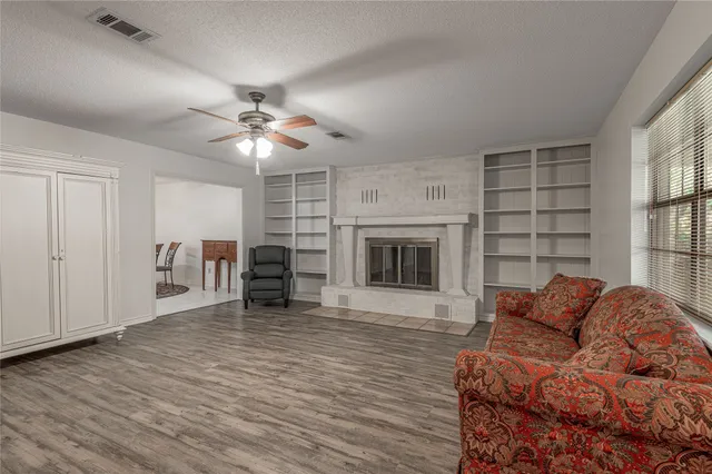 a living room with furniture a fireplace and a large window