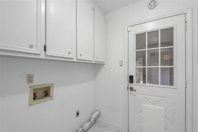 a view of an empty room with wooden floor and cabinets