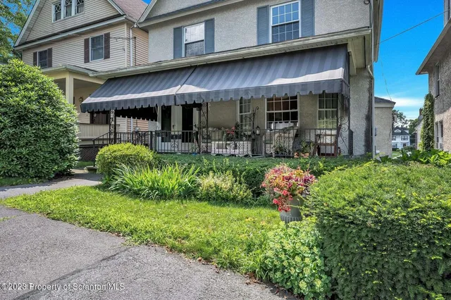 a view of a cafe with table and chairs in front of house