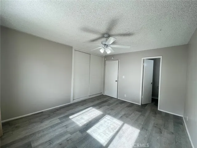 an empty room with wooden floor and chandelier fan