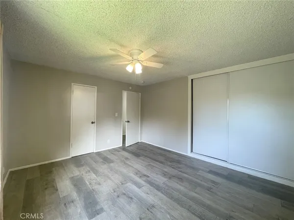 a view of an empty room with closet and a chandelier fan