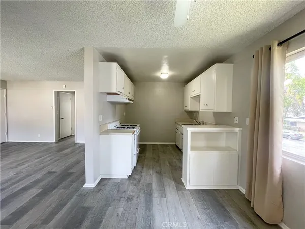 a kitchen with a refrigerator and white cabinets
