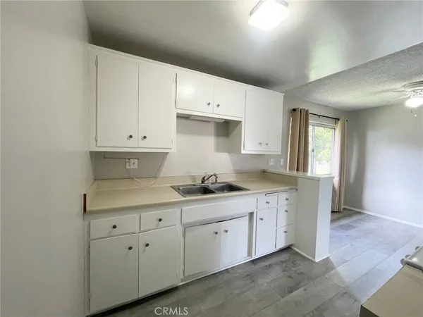 a kitchen with white cabinets and sink
