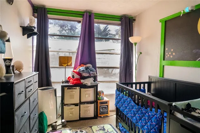a living room with furniture a flat screen tv and a floor to ceiling window