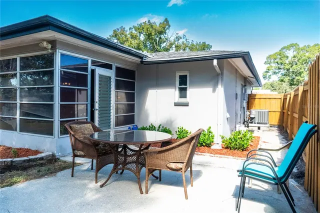 a view of a house with backyard and sitting area