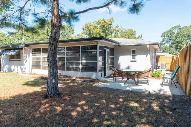 a view of a chair and table in backyard of the house