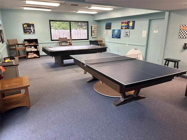 a living room with furniture pool table and a large window