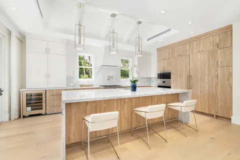 a kitchen with a table chairs sink and cabinets
