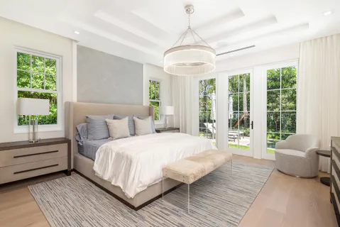 a bathroom with a double vanity sink a mirror and a bathtub next to a window