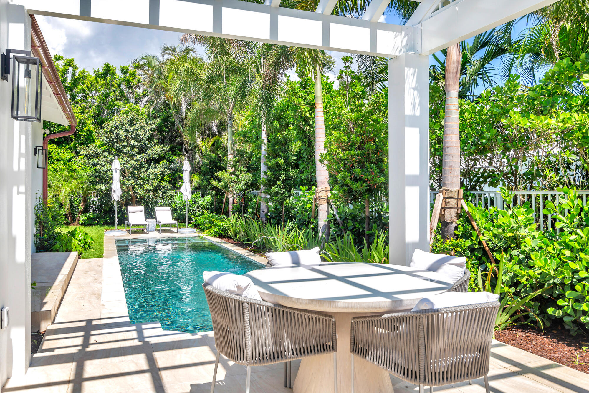 223 Monterey Road Palm Beach, FL 33480 - Photo 44 of 45 a view of a patio with table and chairs potted plants with floor to ceiling window