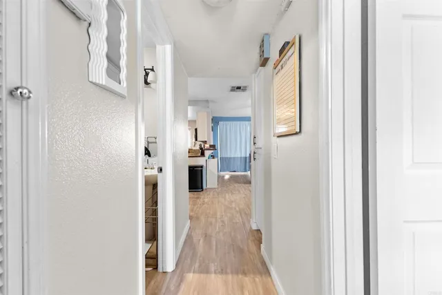 a view of a hallway with wooden floor and staircase