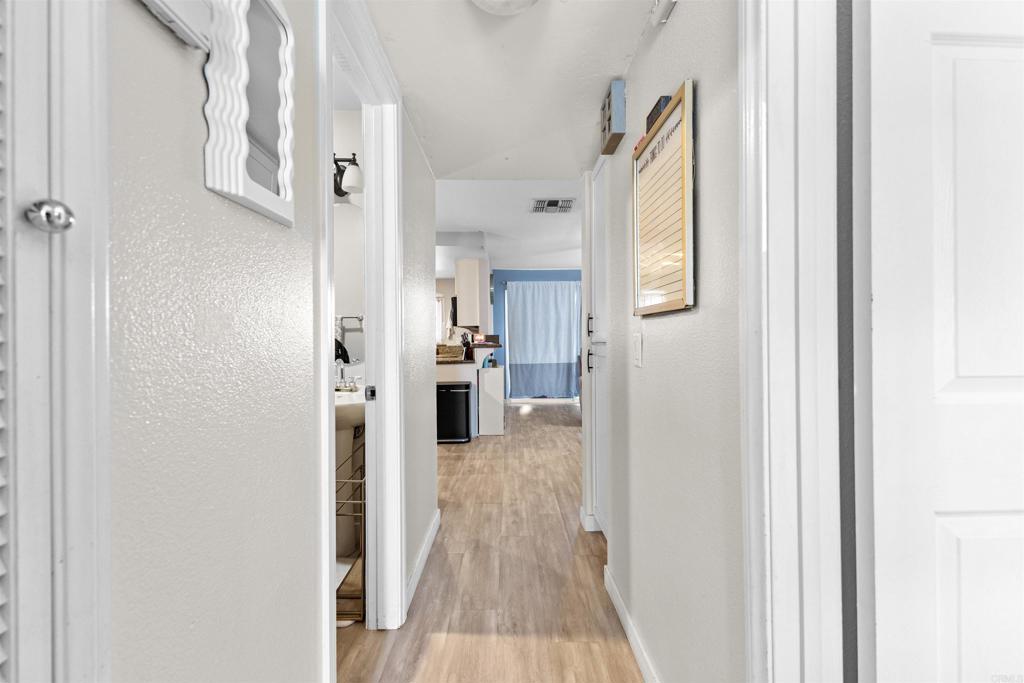 495 San Pasqual Valley Road, Unit 144 Escondido, CA 92025 - Photo 12 of 20 a view of a hallway with wooden floor and staircase
