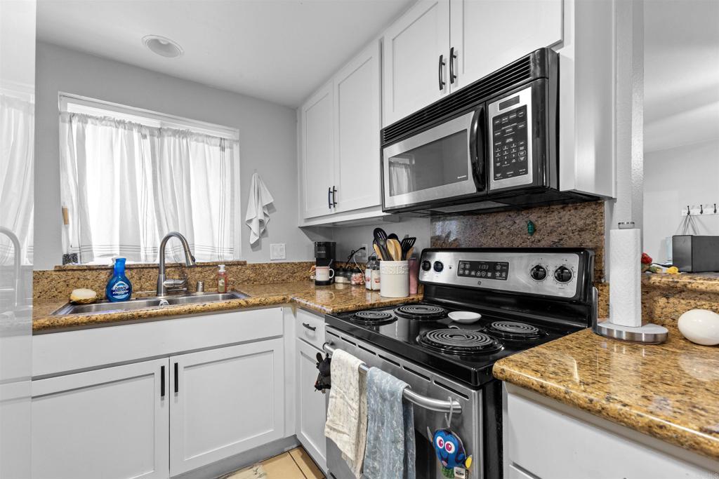 495 San Pasqual Valley Road, Unit 144 Escondido, CA 92025 - Photo 13 of 20 a kitchen with stainless steel appliances granite countertop a stove a sink and a microwave