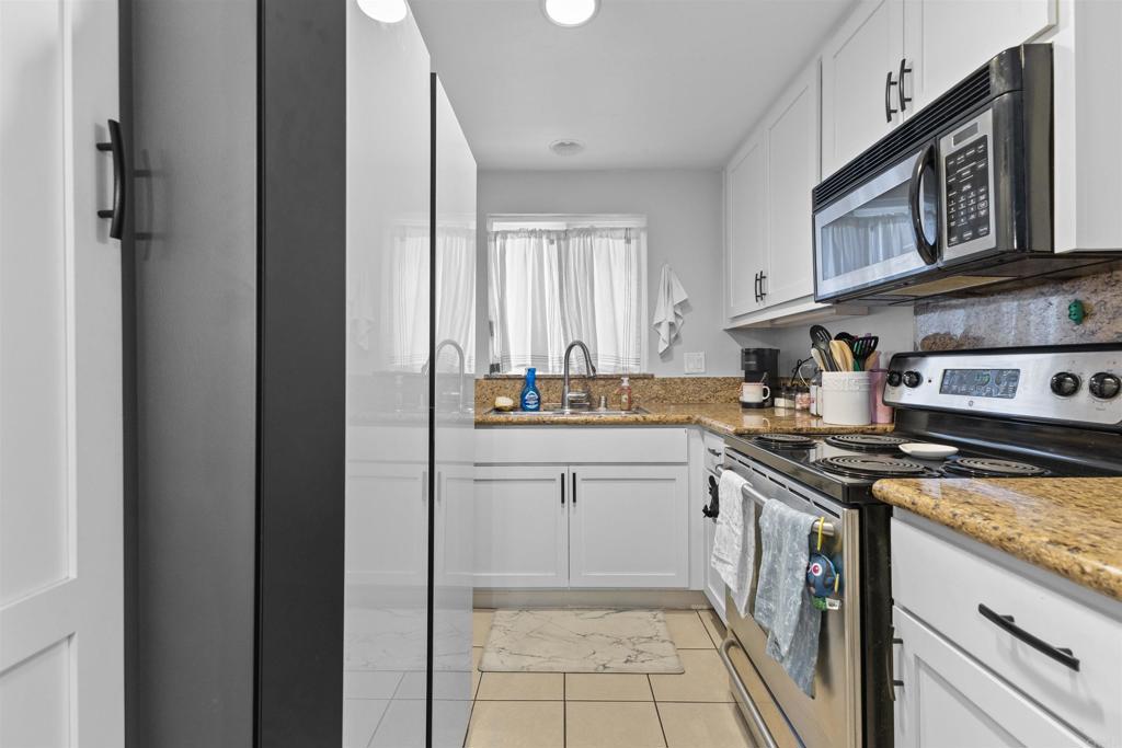 495 San Pasqual Valley Road, Unit 144 Escondido, CA 92025 - Photo 3 of 20 a kitchen with stainless steel appliances granite countertop a stove and a sink