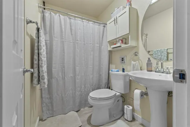 a bathroom with a sink a toilet and shower curtain