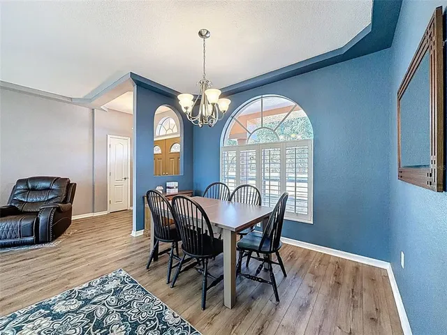 a living room with furniture a flat screen tv and kitchen view