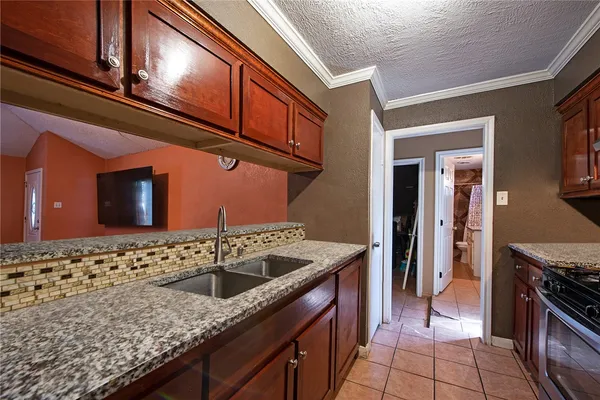 a kitchen with stainless steel appliances granite countertop a sink stove and cabinets
