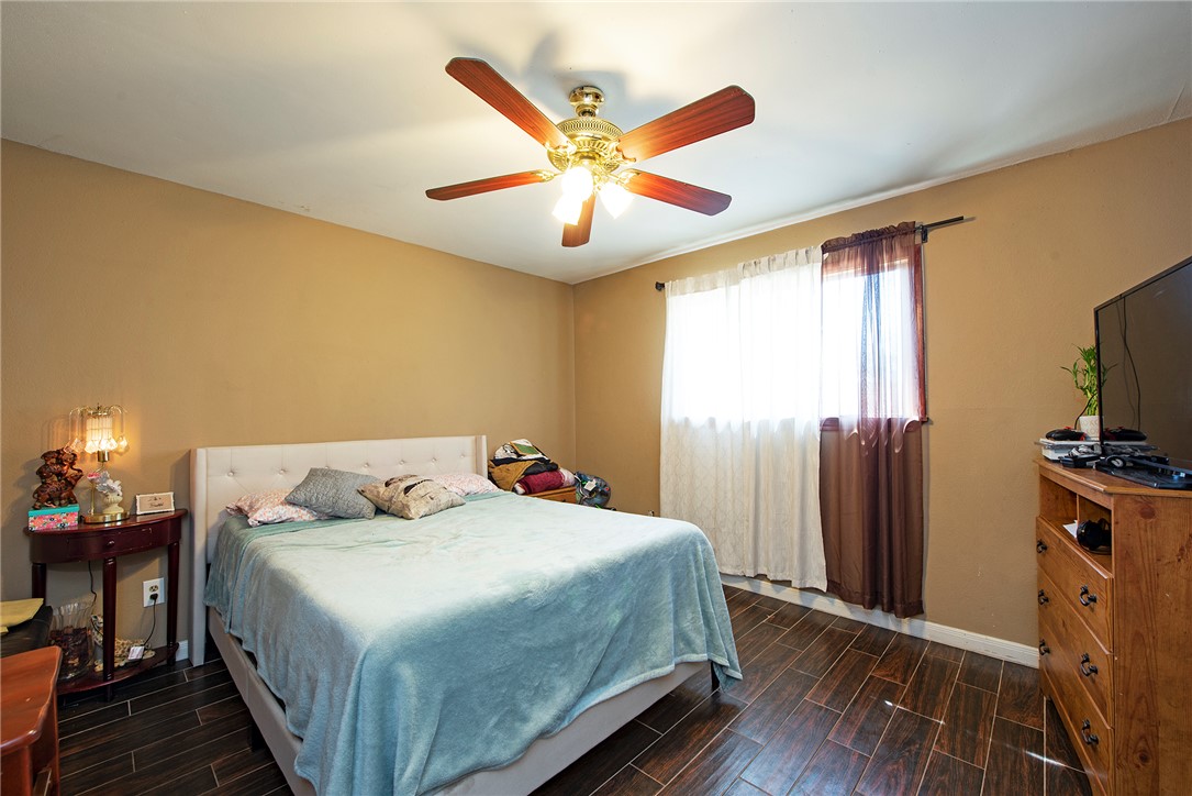 1402 South 5th Street Conroe, TX 77301 - Photo 10 of 14 a bedroom with a bed and a chandelier