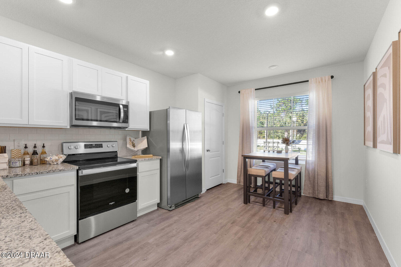 44 Center Grande Road Ormond Beach, FL 32174 - Photo 9 of 20 a kitchen with stainless steel appliances a stove a sink a refrigerator a dining table and chairs