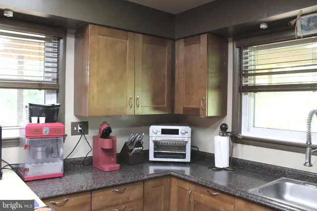 a kitchen with kitchen island granite countertop a sink cabinets and window
