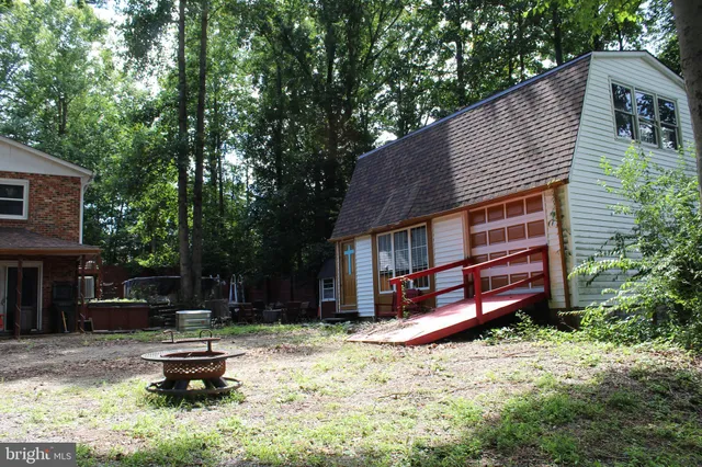 a backyard of a house with a small yard and large tree