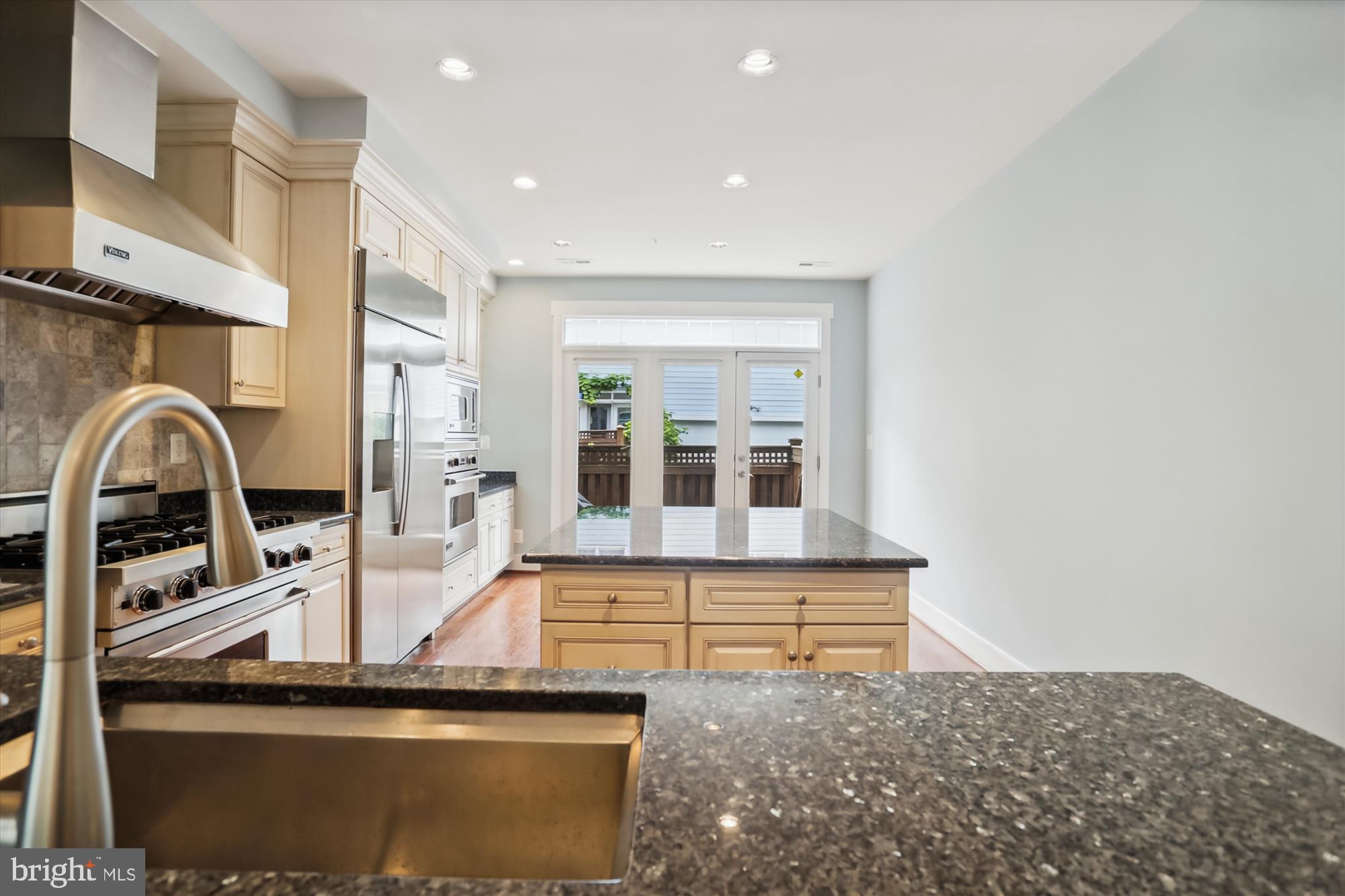 9539 Ament Street Silver Spring, MD 20910 - Photo 14 of 40 a view of a kitchen with a sink and dishwasher a kitchen island with wooden cabinets