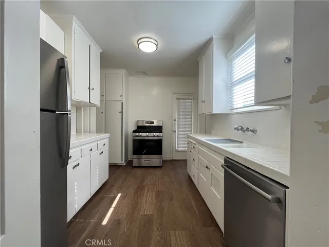 a kitchen with white cabinets and white appliances