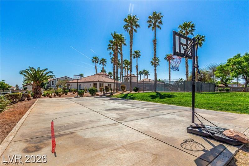 3318 North Decatur Boulevard, Unit 2152 Las Vegas, NV 89130 - Photo 52 of 58 A private basketball court offers recreational space amid lush green grass and towering palms.