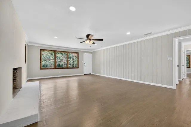 an empty room with windows and ceiling fan view