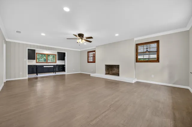 a view of an empty room with a window and fireplace