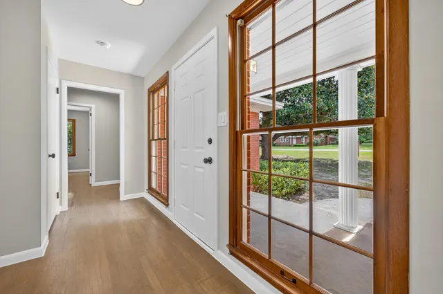 a view of hallway with a large window and wooden floor