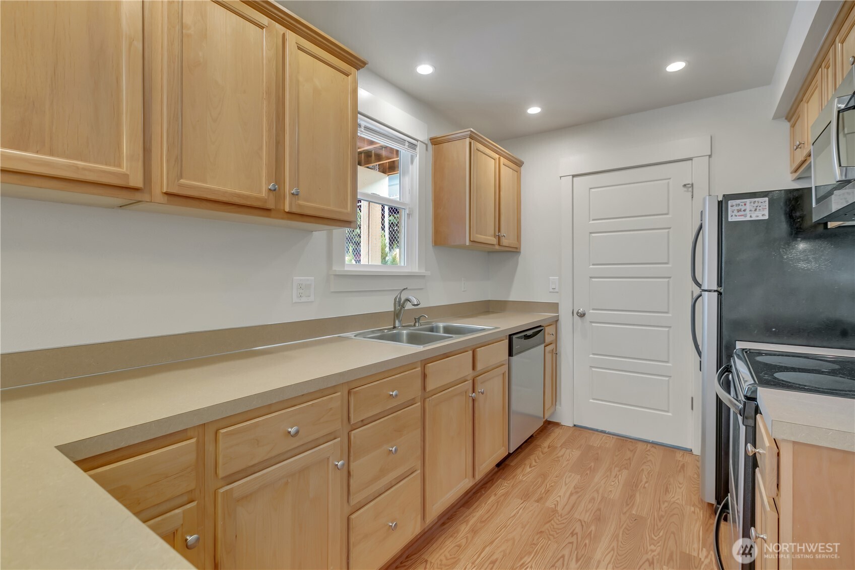 4945 North Pearl Street Ruston, WA 98407 - Photo 9 of 22 a kitchen with a sink stainless steel appliances and cabinets