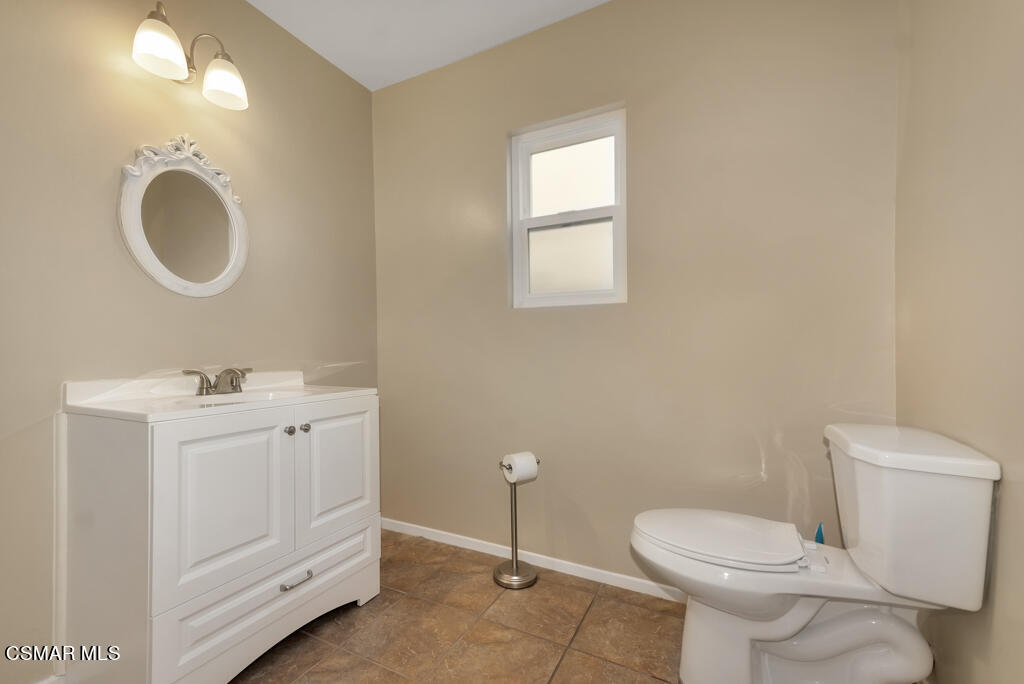 1300 Rachel Drive Oxnard, CA 93030 - Photo 19 of 50 a bathroom with a toilet a sink a mirror and a window