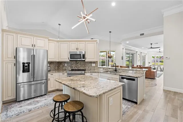 a kitchen with a center island appliances and cabinets