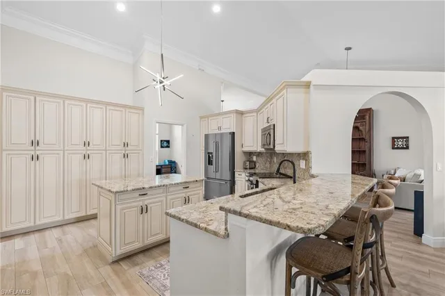 a kitchen with granite countertop kitchen island white cabinets and stainless steel appliances