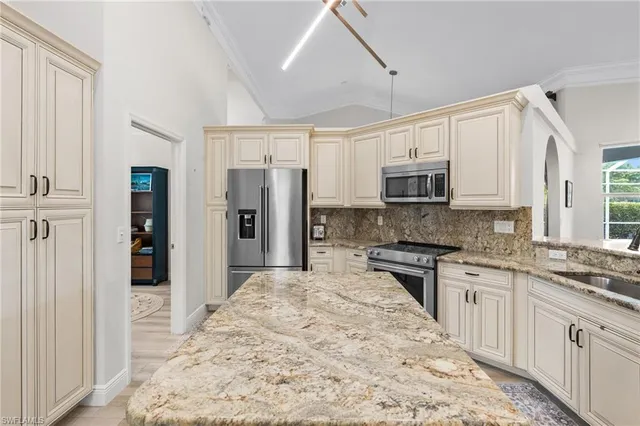 a large kitchen with cabinets stainless steel appliances and a window