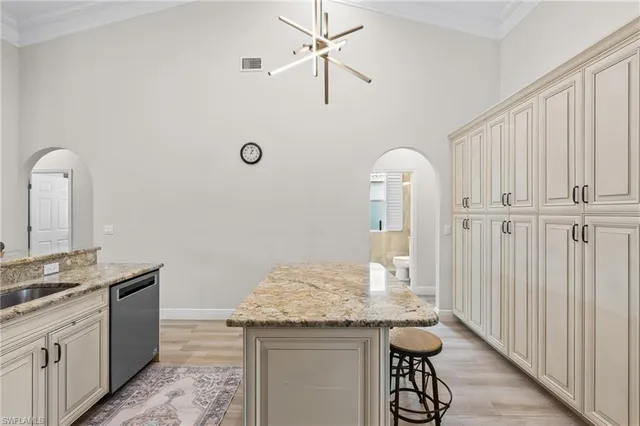 a kitchen with granite countertop a sink cabinets and wooden floor