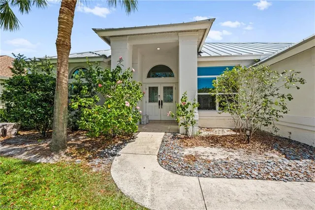 a view of a house with pool and chairs