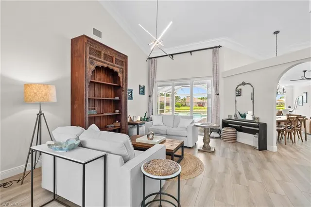 a living room with furniture a dining table and chairs with wooden floor